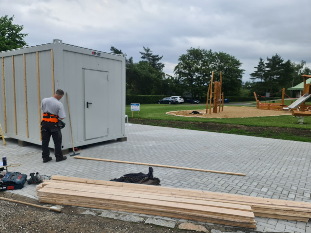 Obložení kontejneru, okolí s hřištěm